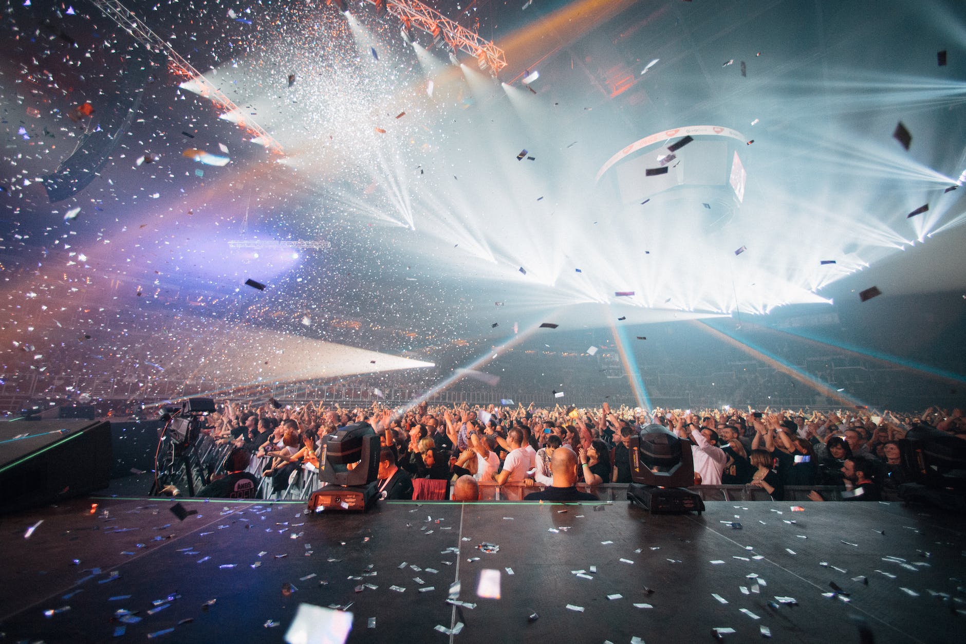 a crowd in a live performance with confetti falling
